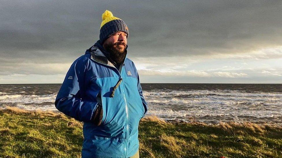 Chris Howard photographed wearing a hat in front of the sea