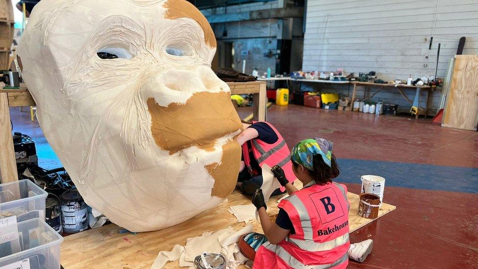 An artist painting a gorilla model