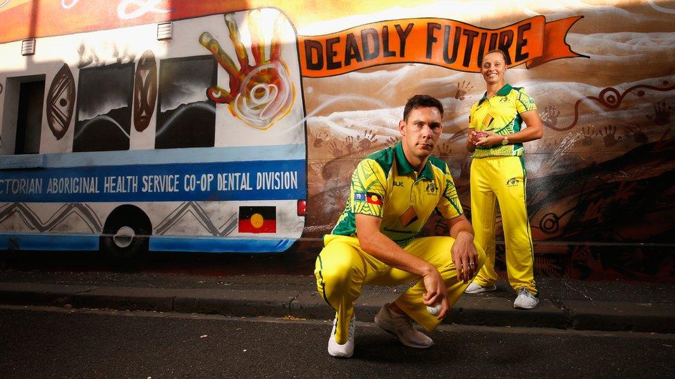 Indigenous cricketers Scott Boland and Ashleigh Gardner in front of an Aboriginal art mural