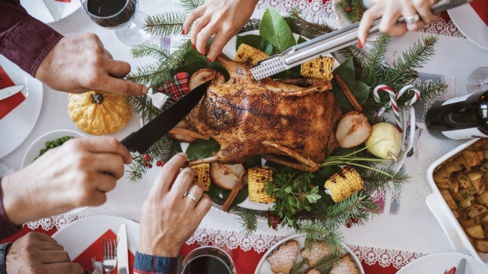 Hands reaching over Christmas meal