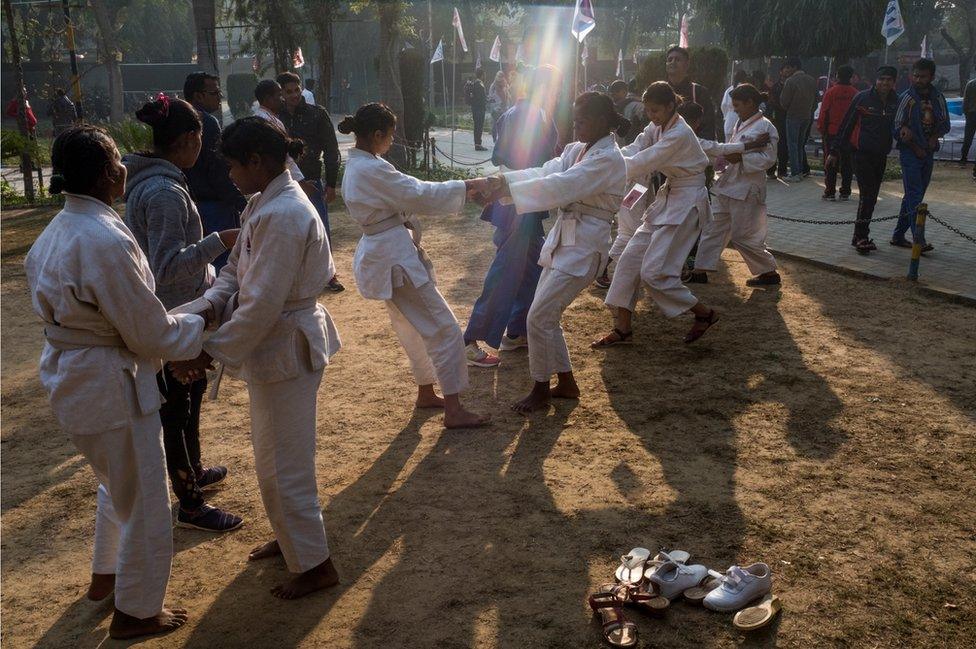 A row of girls wrestle