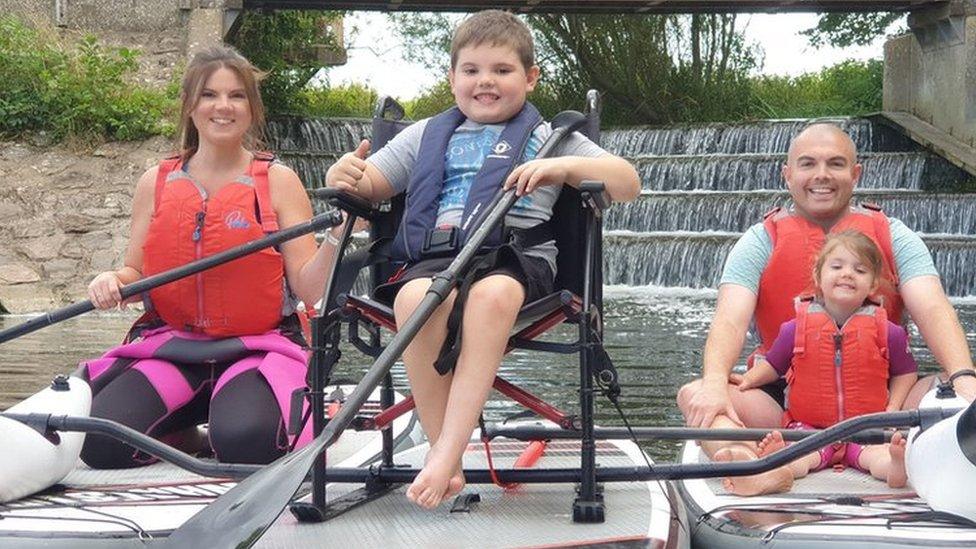 Oscar and his family paddle boarding