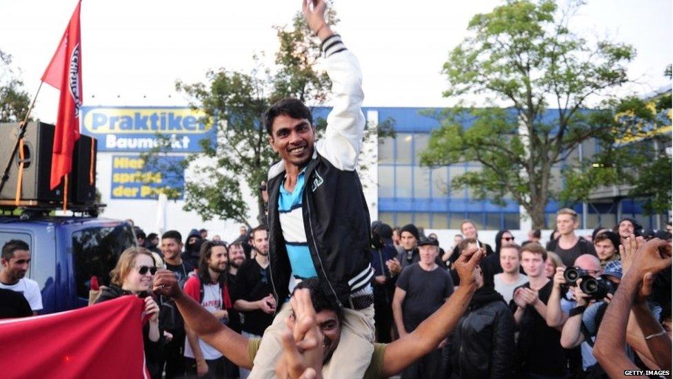 Refugees celebrate with leftist sympathizers at a shelter for asylum seekers on 29 August