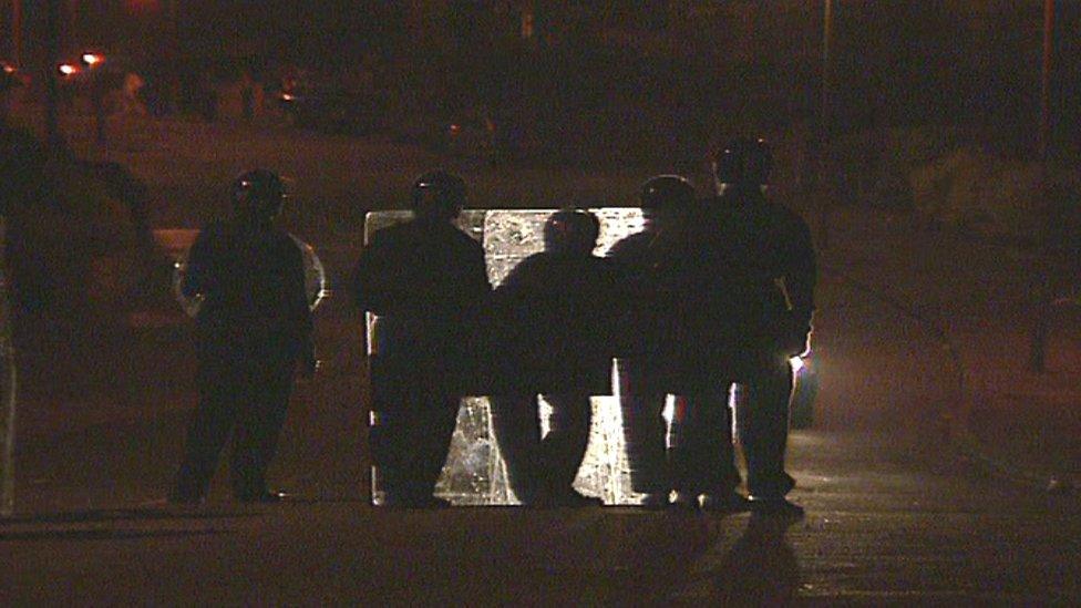 Riot police face rioters during the Ely riots