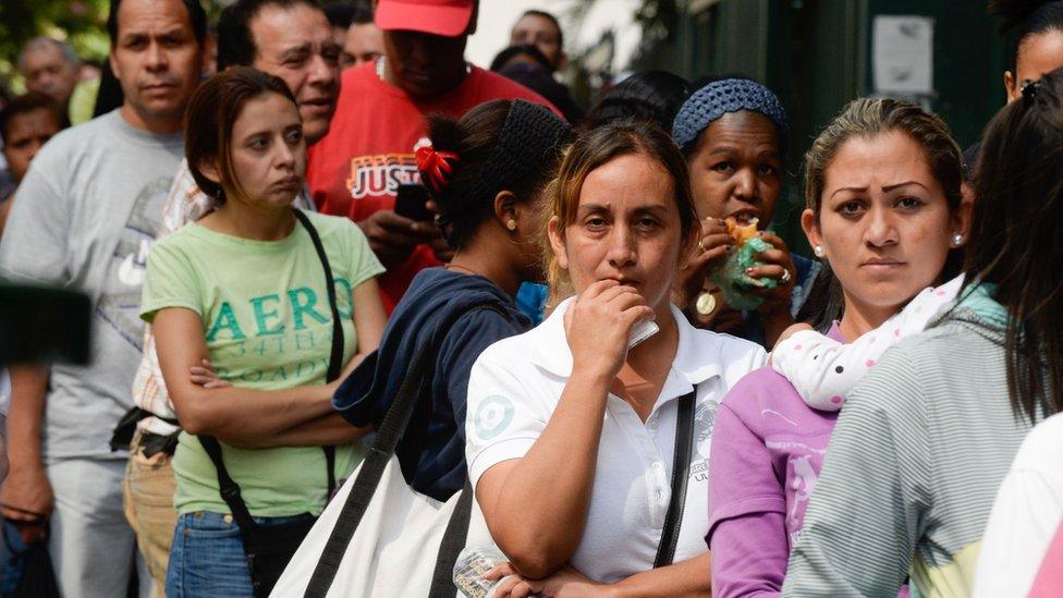 People queuing outside a supermarket in Caracas