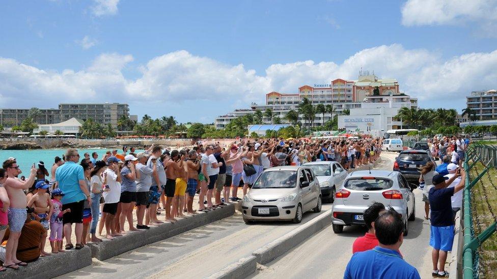 Image of people watching planes take off in Sint Maarten, taken at Maho Beach