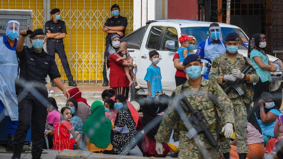 Migrants line up for document checks during immigration operation to arrest undocumented migrants in Kuala Lumpur