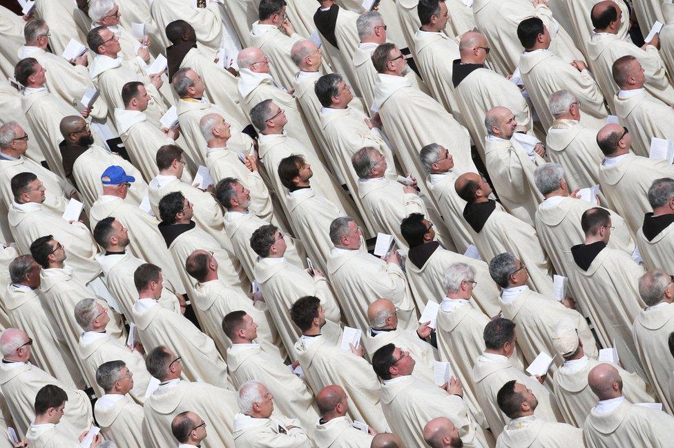 Priests are seen as Pope Francis leads a Holy Mass.