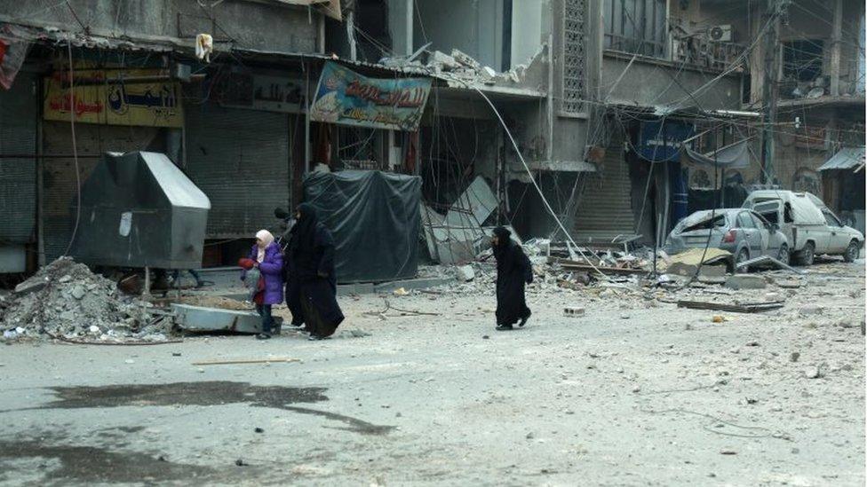 Syrian women run for cover following Syrian government bombardment on the town of Douma in the rebel-held enclave of Eastern Ghouta on the eastern outskirts of the capital Damascus on March 10, 2018.