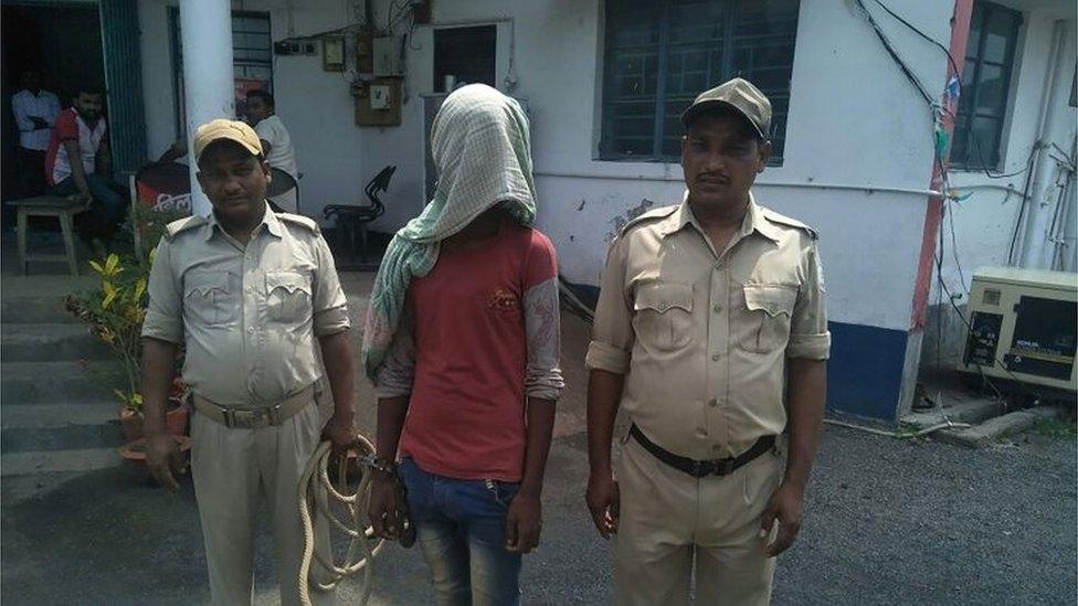 This photo taken on May 6, 2018 shows an alleged rapist (C) being held by Indian police, in the case of a 17-year-old girl who was raped and set on fire, at Mufasil police station before being sent to judicial custody in Pakur district, in India"s eastern Jharkhand state.