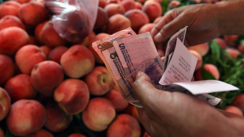 Shopper buying peaches with cash