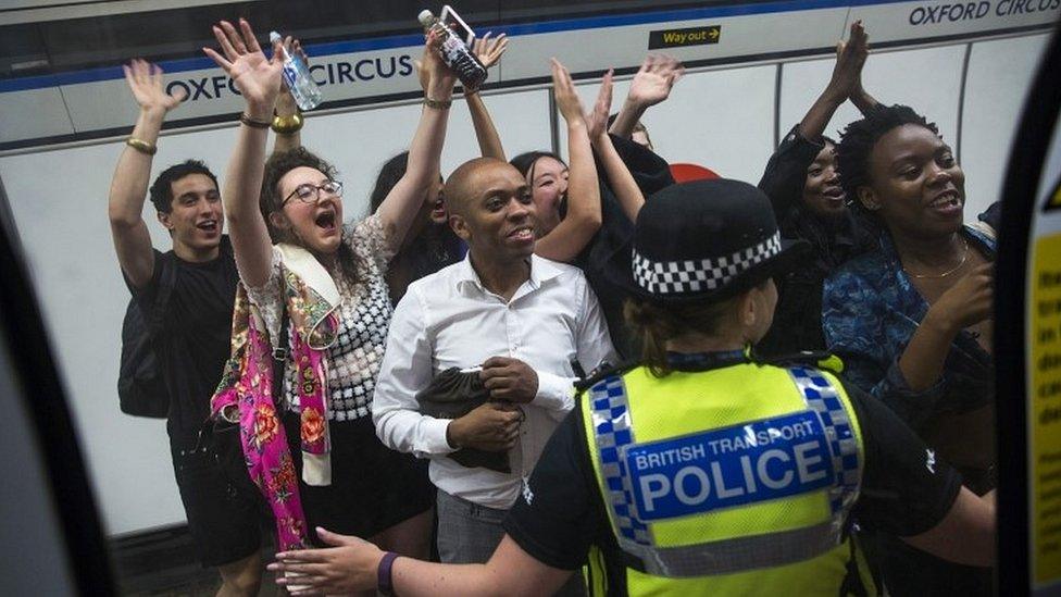 Members of the public wave and cheer as they see London Mayor Sadiq Khan in a tube train carriage