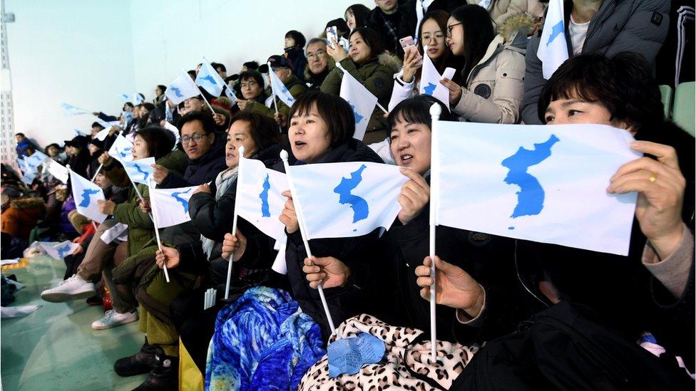 People wave the Korean Unification Flag, while the joint Korean women"s hockey team faces Sweden - 5 February 2018