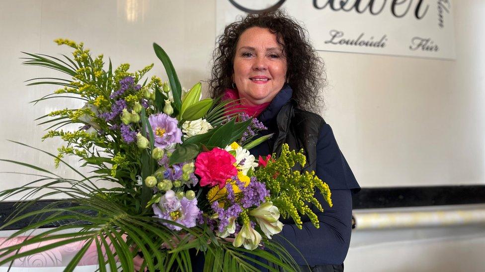 Kathryn Berbillion holding a bouquet of flowers