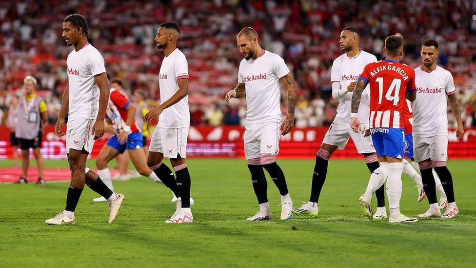 Sevilla players wear shirts reading "it's over", in support of Hermoso, ahead of their La Liga match against Girona FC