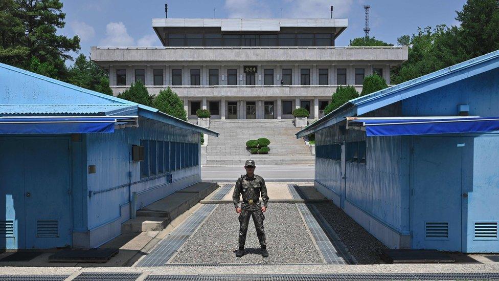 A South Korean soldier stands guard before the Military Demarcation Line (MDL) during a regular media tour at the border truce village of Panmunjom in the Demilitarised Zone