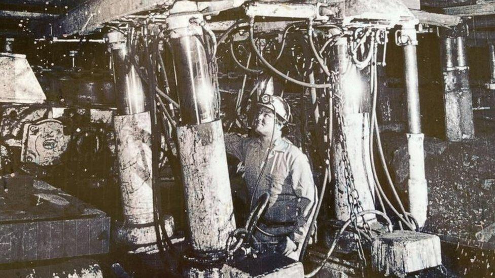 Black and white picture of a miner working in a mine