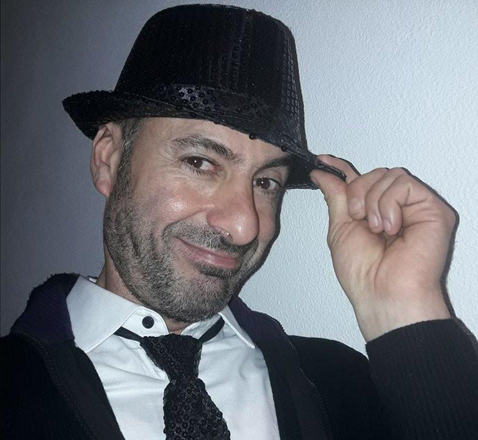 A picture of Andrea Cerulli smiling in a black sequinned trilby hat