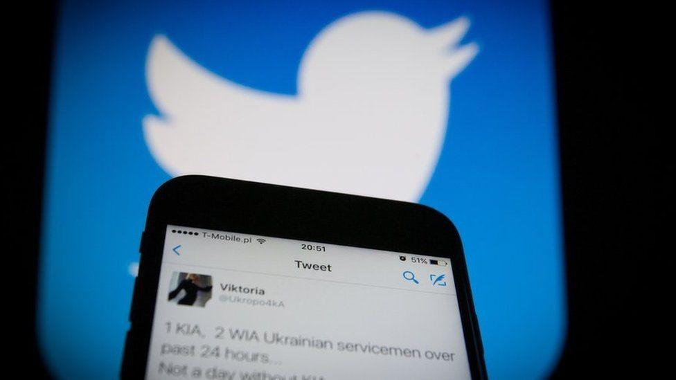 Twitter logo and twitter on a mobile phone