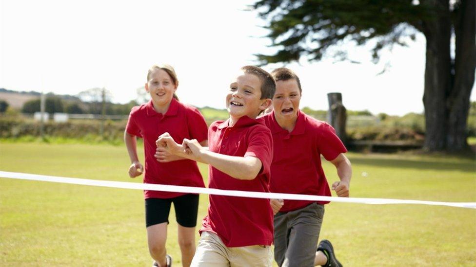 Children running over finish line