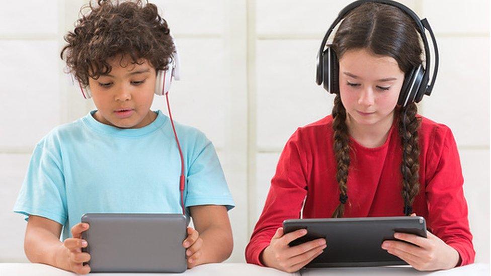 A boy and girl using tablets