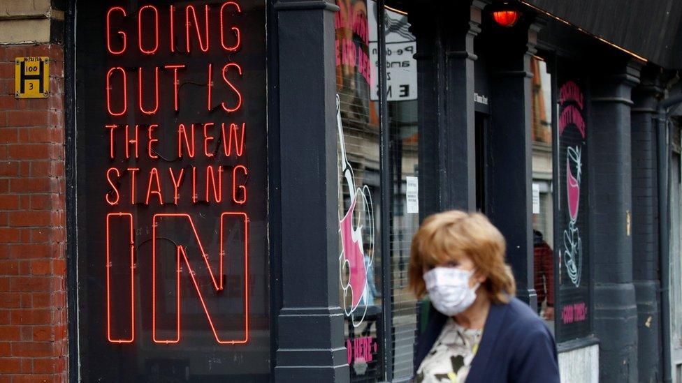 Woman walking past pub signage