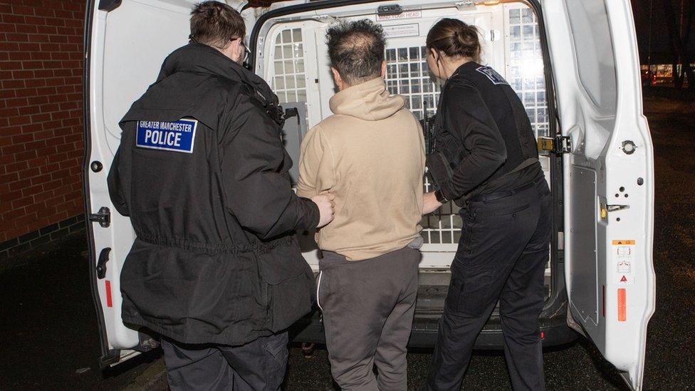 A man being arrested and taken into the back of a GMP police wagon