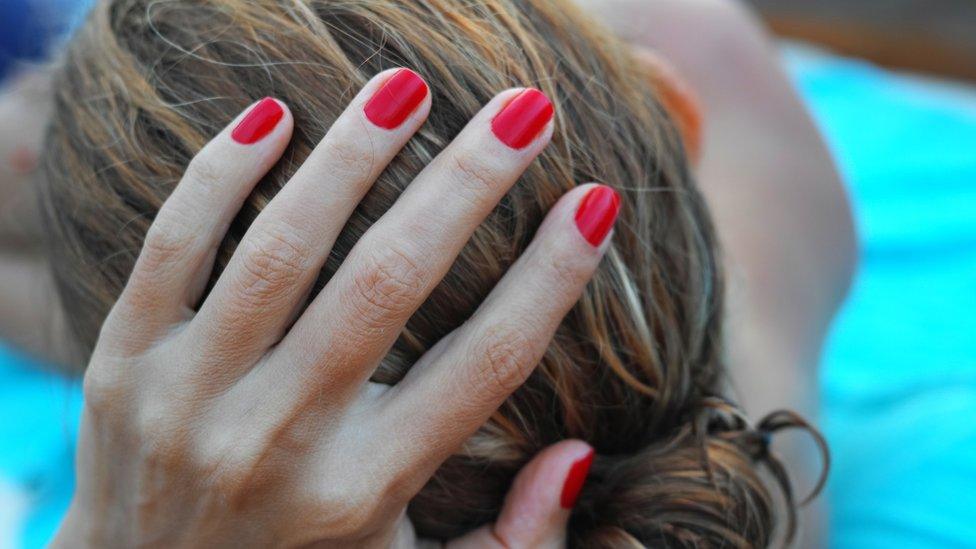 woman holding the back of her head