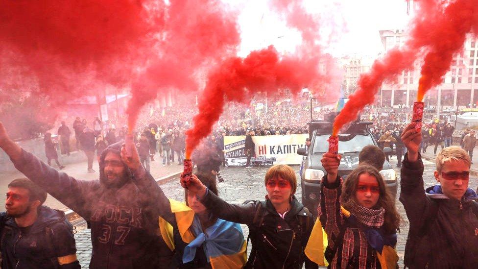 Protesters holding smoke grenades in Kyiv