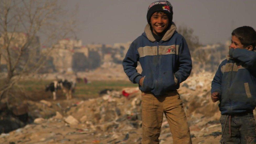 Boys stand on the edge of the Jaramana district of Damascus