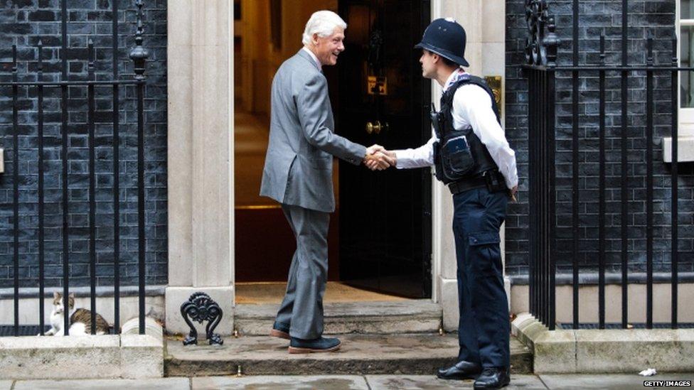 Bill Clinton shaking hands with a police officer outside 10 Downing St