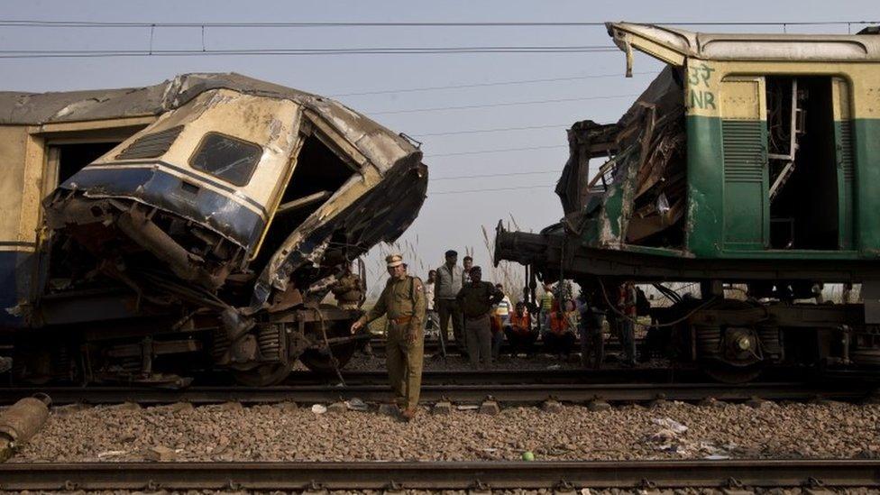 Railway workers, policemen and onlookers surround the destroyed coaches after two trains collided at Janauli in the northern state of Haryana, India, Tuesday, Dec. 8, 2015