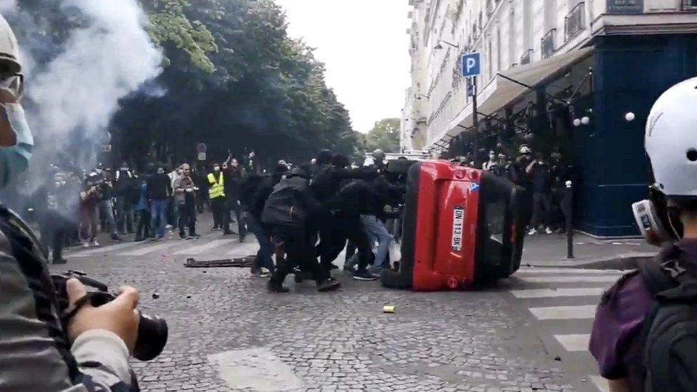 Protesters push a car to make a barrier during a protest in Paris, France, 16 June 2020