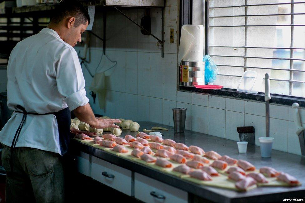 Baker making ham croissants in Venezuela