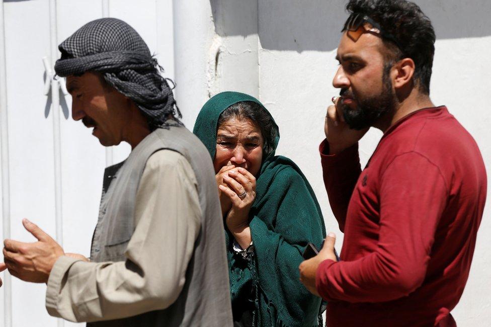 Relatives of Afghan victims mourn outside a hospital after the blast in Kabul, 31 May