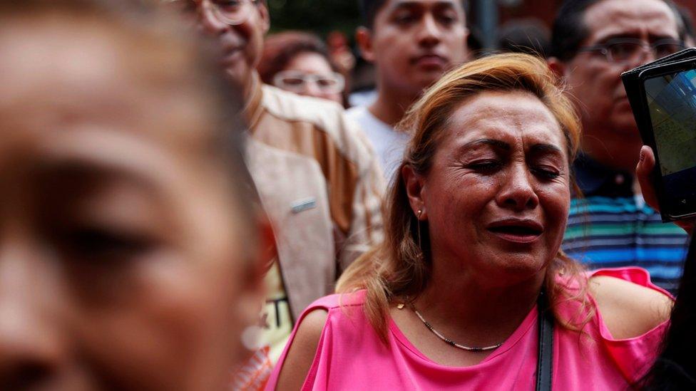 A woman reacts as she sings one of José José's songs to pay tribute to the Mexican singer and songwriter in Mexico City