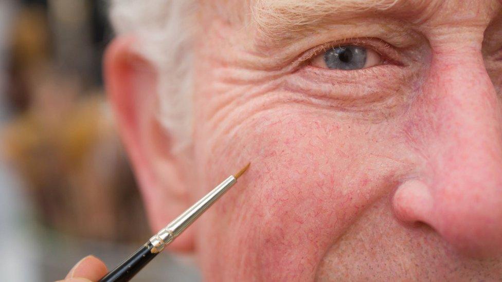 King Charles III waxwork figure being painted with fine brush