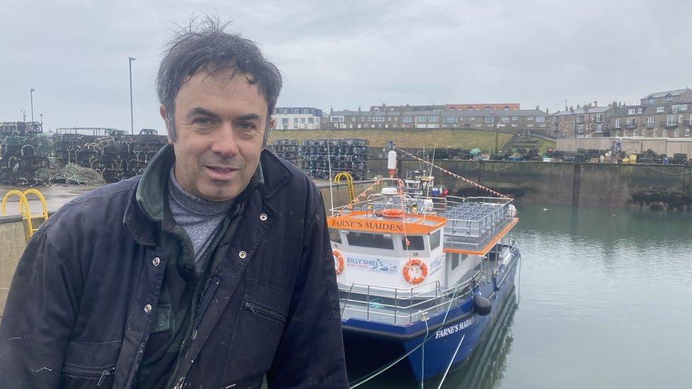 One of the skippers William Shiel in front of one of his boats in Seahouses harbour