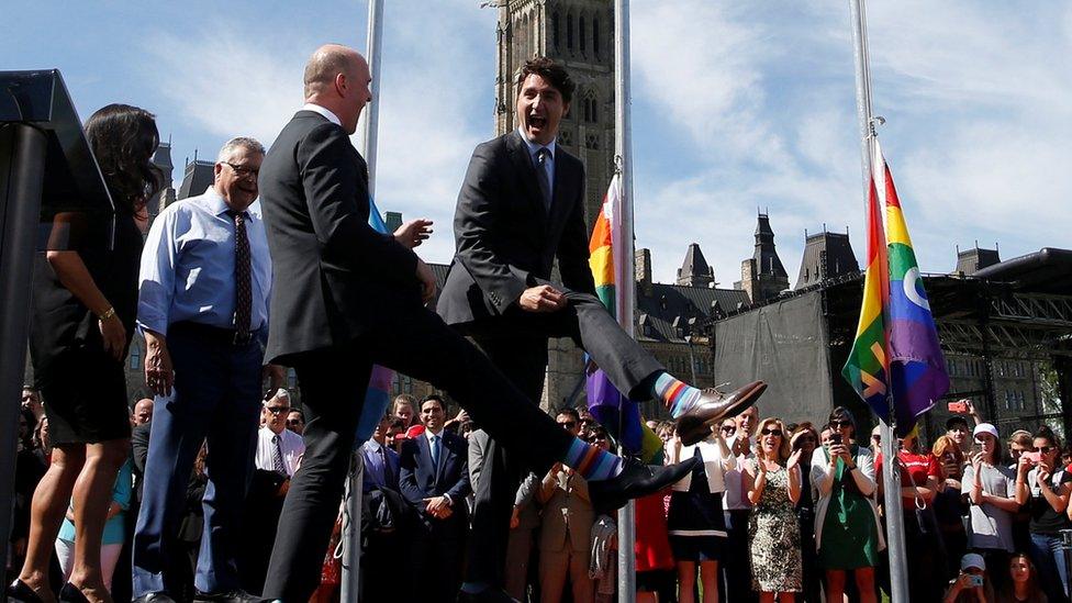 Canada's Prime Minister Justin Trudeau compares socks with Liberal MP Randy Boissonnault during a pride flag raising ceremony on Parliament Hill in Ottawa, Ontario, 25 June 2017