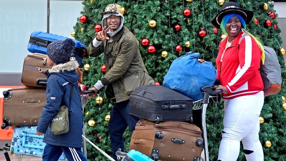 A family with suitcases at Gatwick