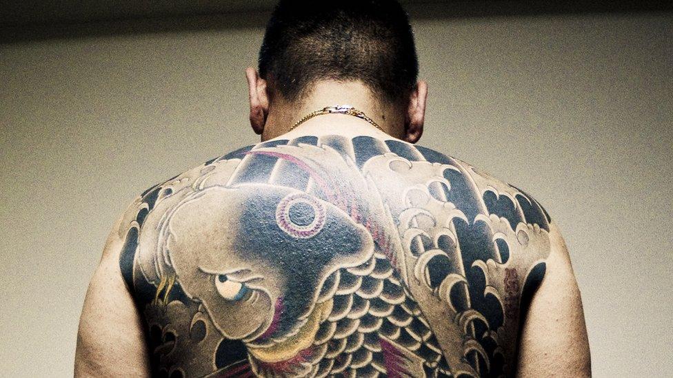 A man with tattoos on his back