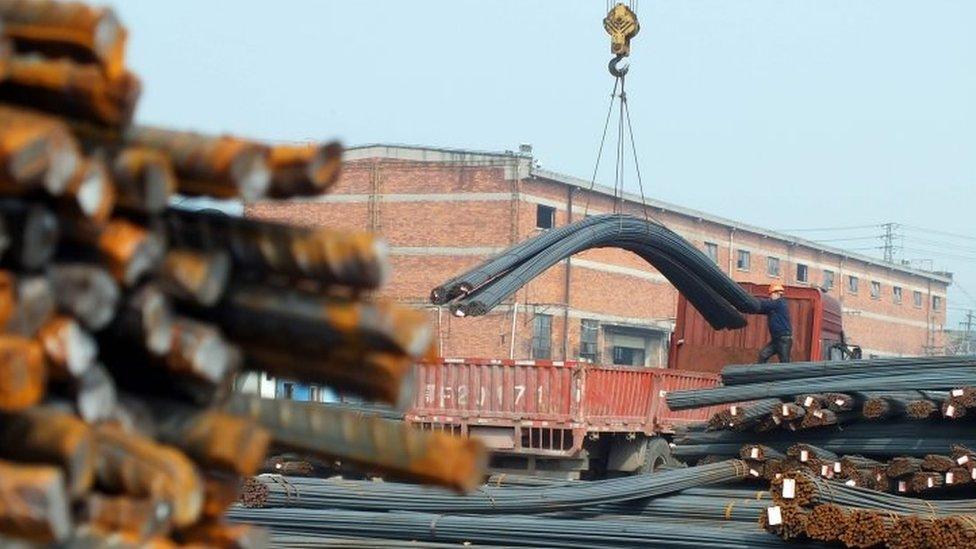 Chinese workers loading steel onto a truck at a steel market in Yichang, in central China's Hubei province (04 March 2016)