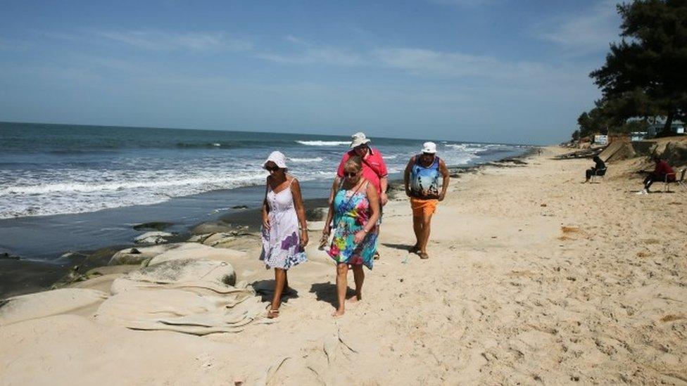 British tourists walking on Gambian beach