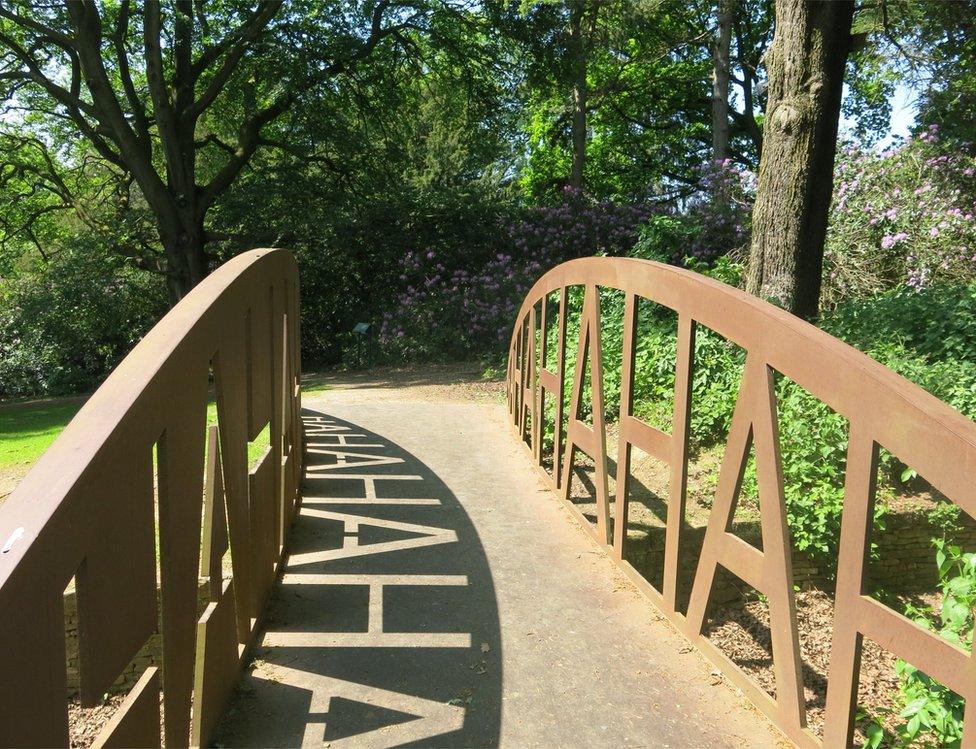 The words "Ha Ha" reflected by shadow on a bridge