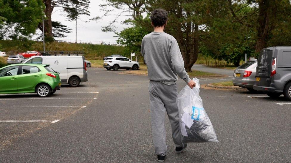 Defendant leaves court holding a bag if his belongings