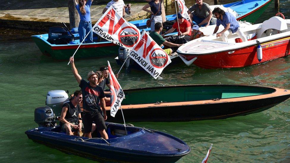 People on boats hold flags reading "No big ships"