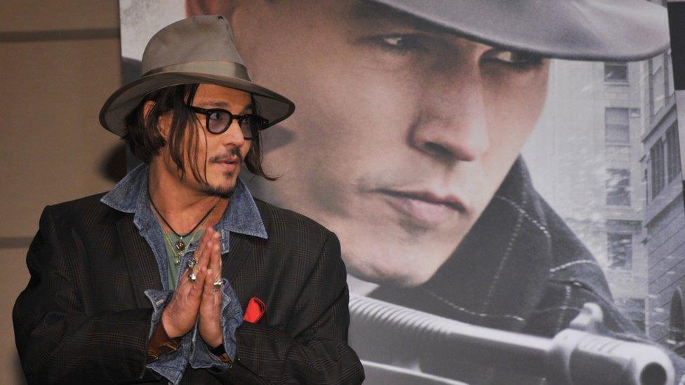 US actor Jonny Depp stands in front of a Public Enemies film poster in Tokyo, Japan. Photo: 9 December 2009