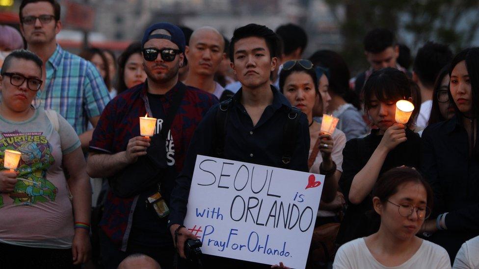 People gather during a vigil in downtown Seoul to remember victims of the shooting at an Orlando nightclub on June 13, 2016 in Seoul, South Korea