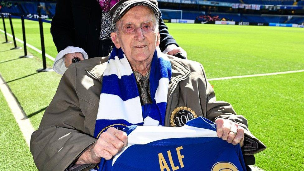 Alf Wells holding a Chelsea football shirt bearing his name