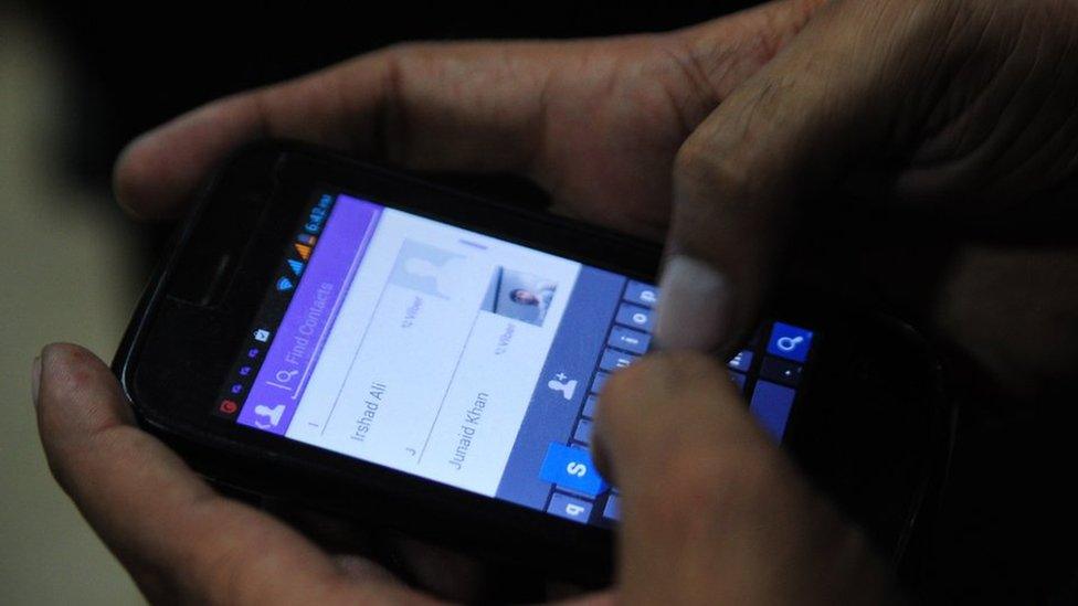A Pakistan man tries to connect to chat with his friend on his mobile in the port city of Karachi